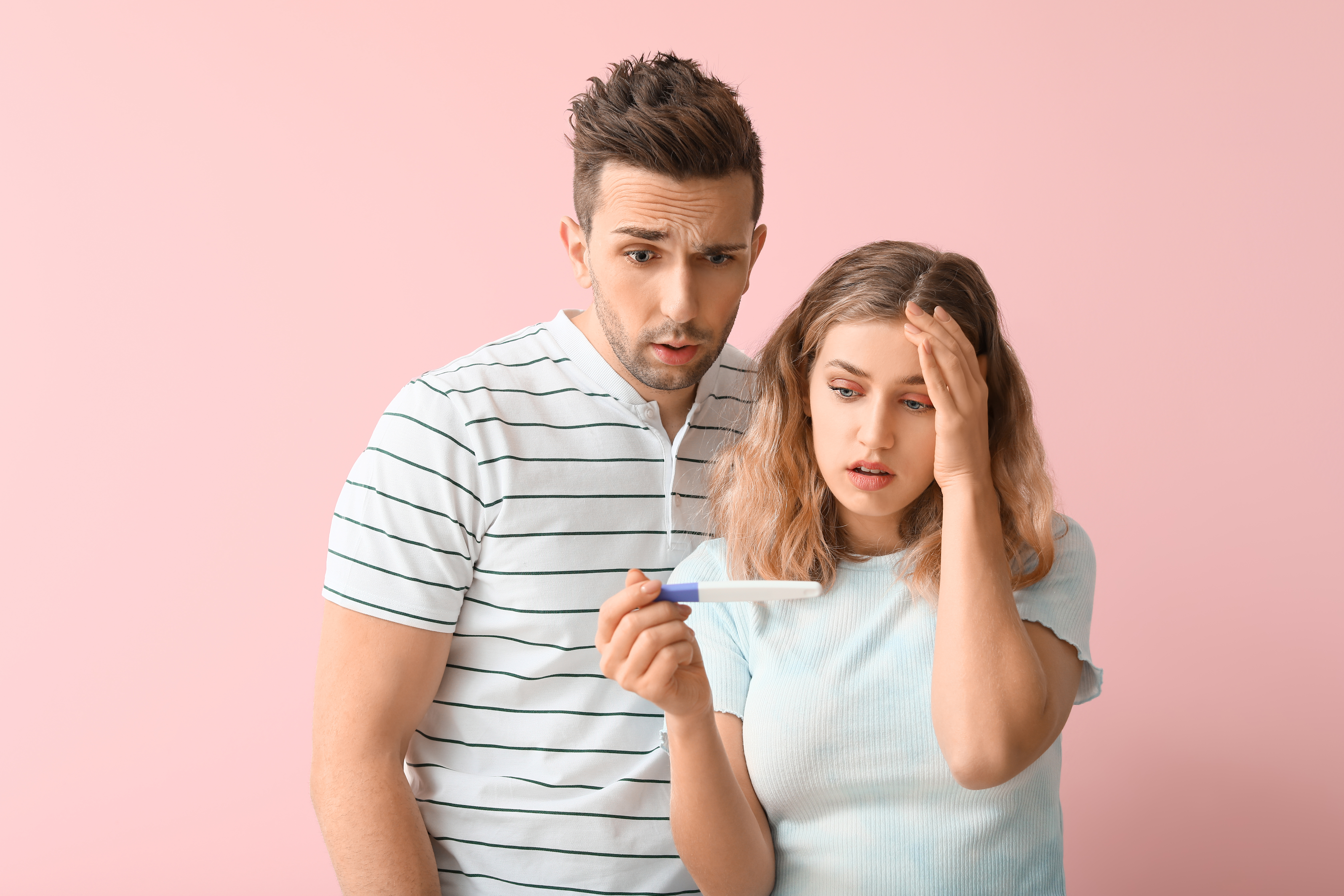 Un hombre y una mujer mirando un test de embarazo | Foto: Shutterstock