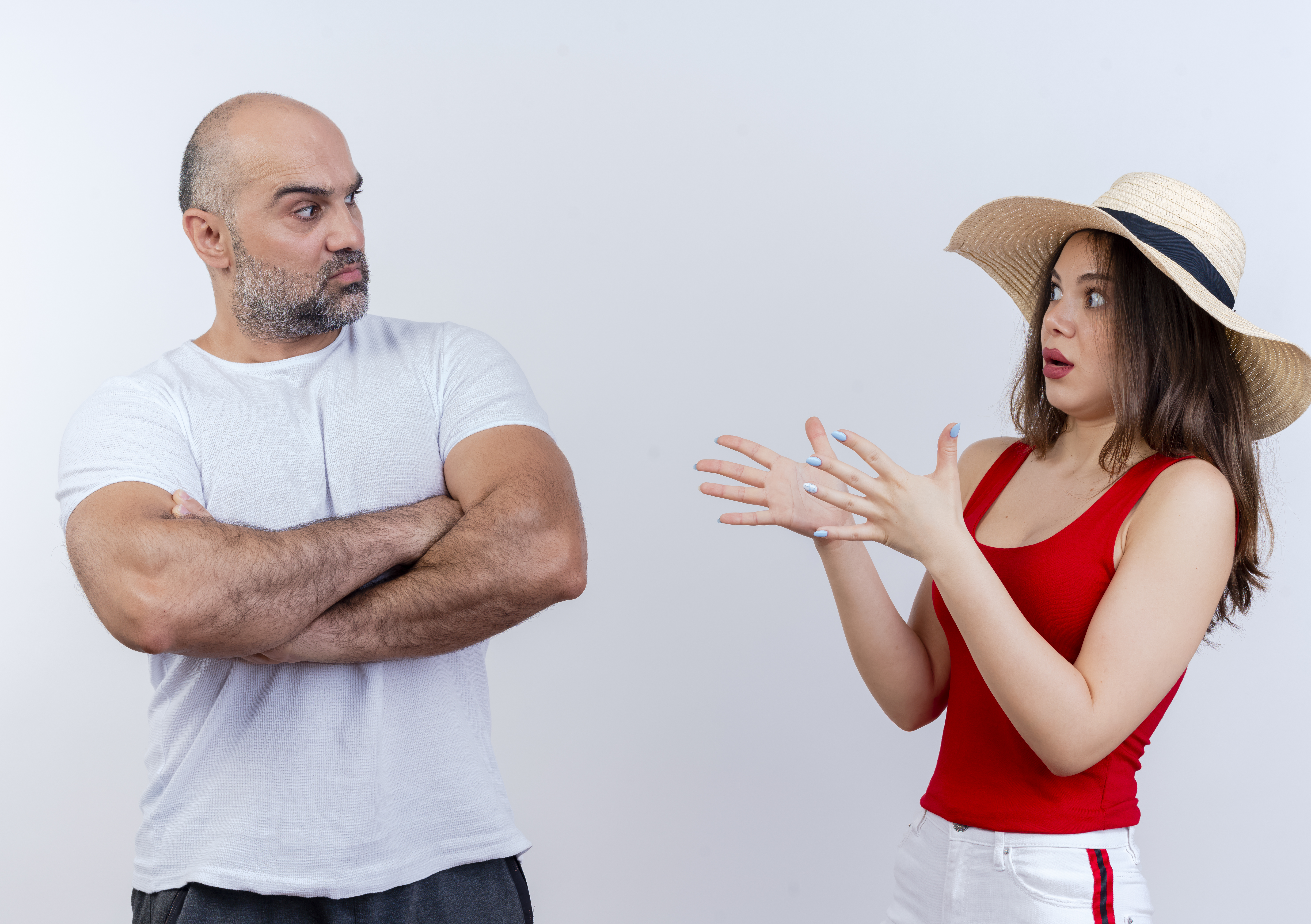 Hombre mostrando su desaprobación a una mujer que lleva un top y un sombrero rojos | Fuente: Freepik