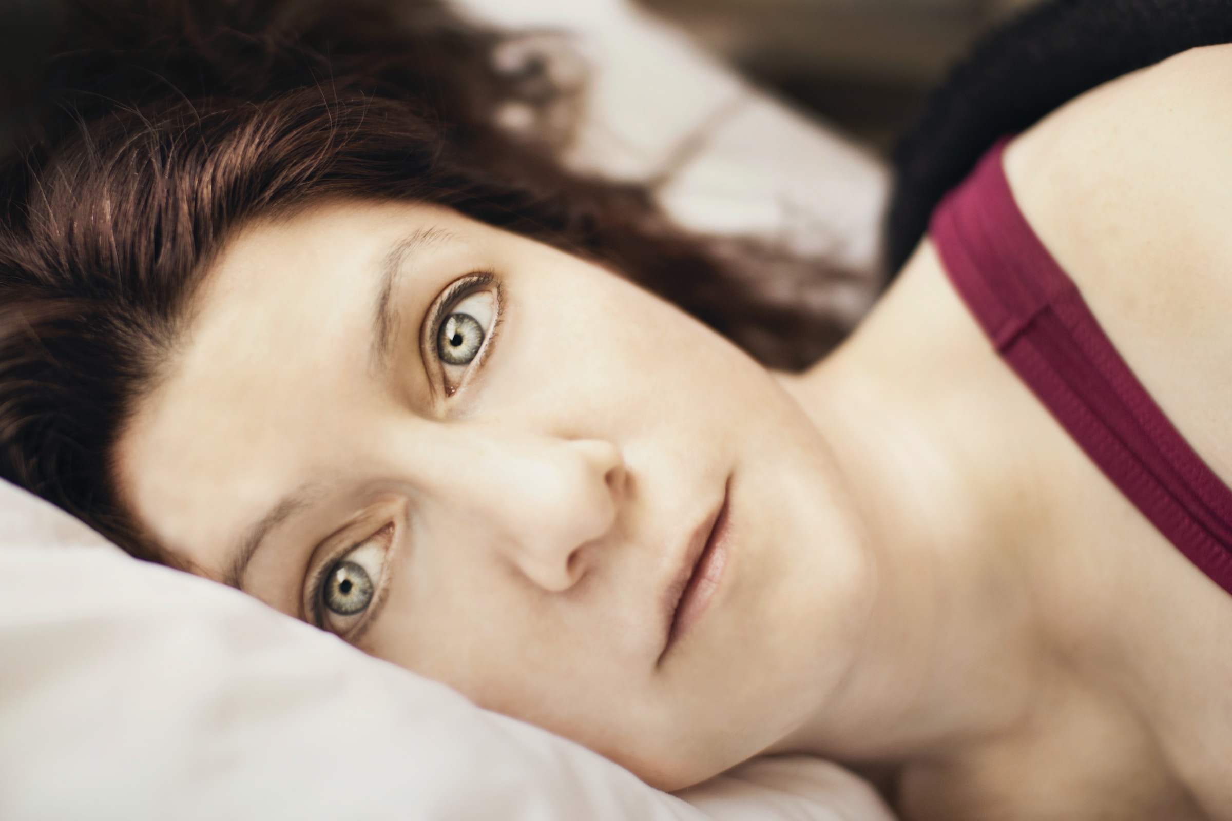 Una mujer yace en la cama completamente despierta mientras contempla sus problemas. | Foto: Unsplash