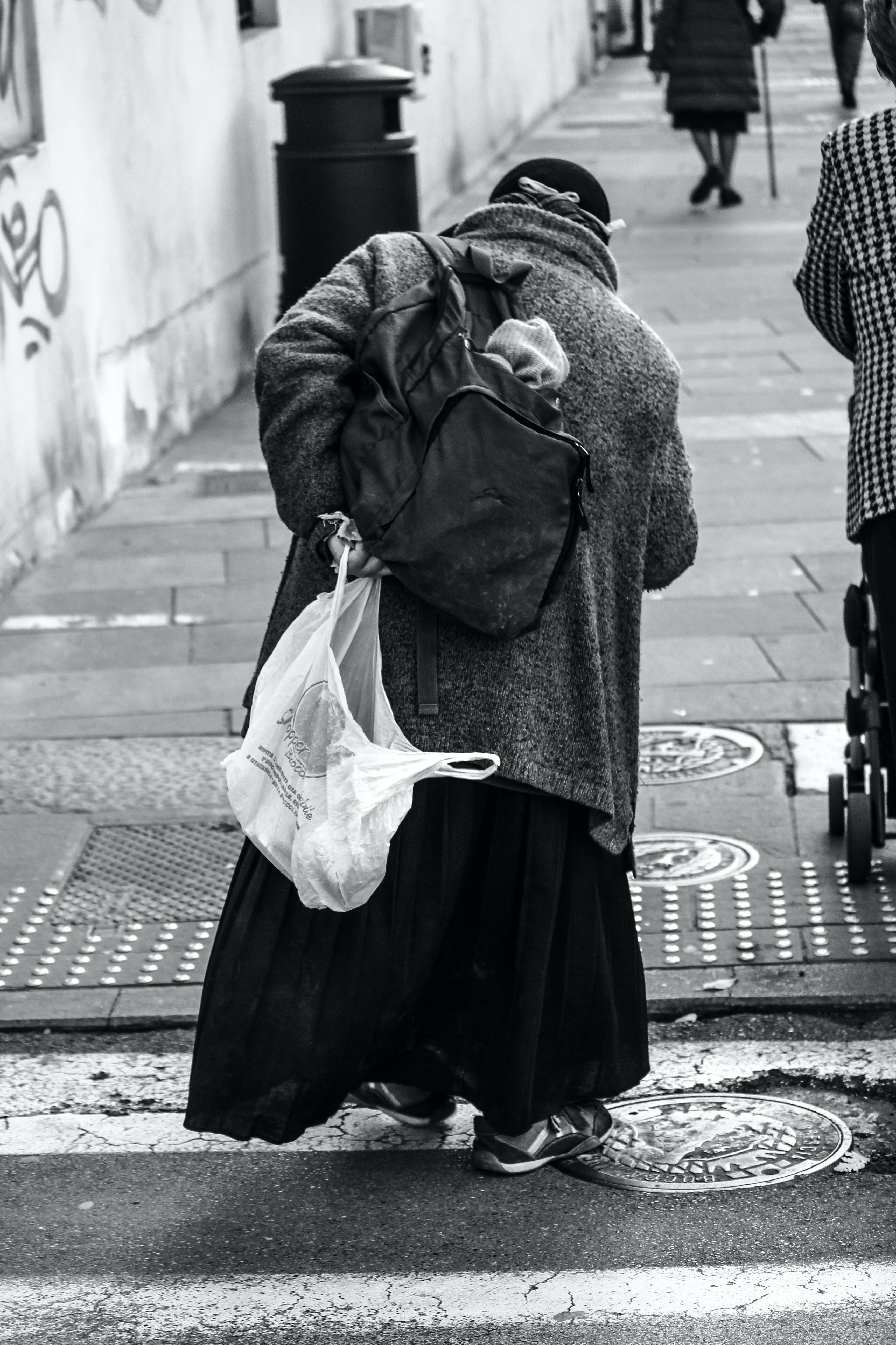 Una anciana sin hogar subiendo a una acera. | Foto: Pexels