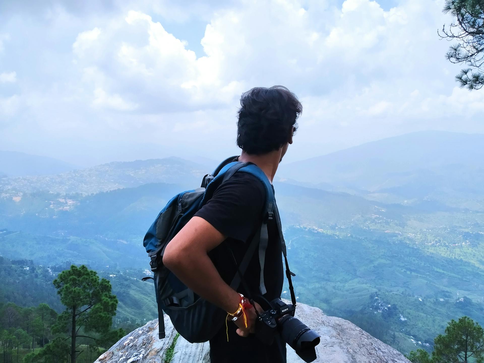 Un fotógrafo de pie en la cima de una montaña | Fuente: Pexels