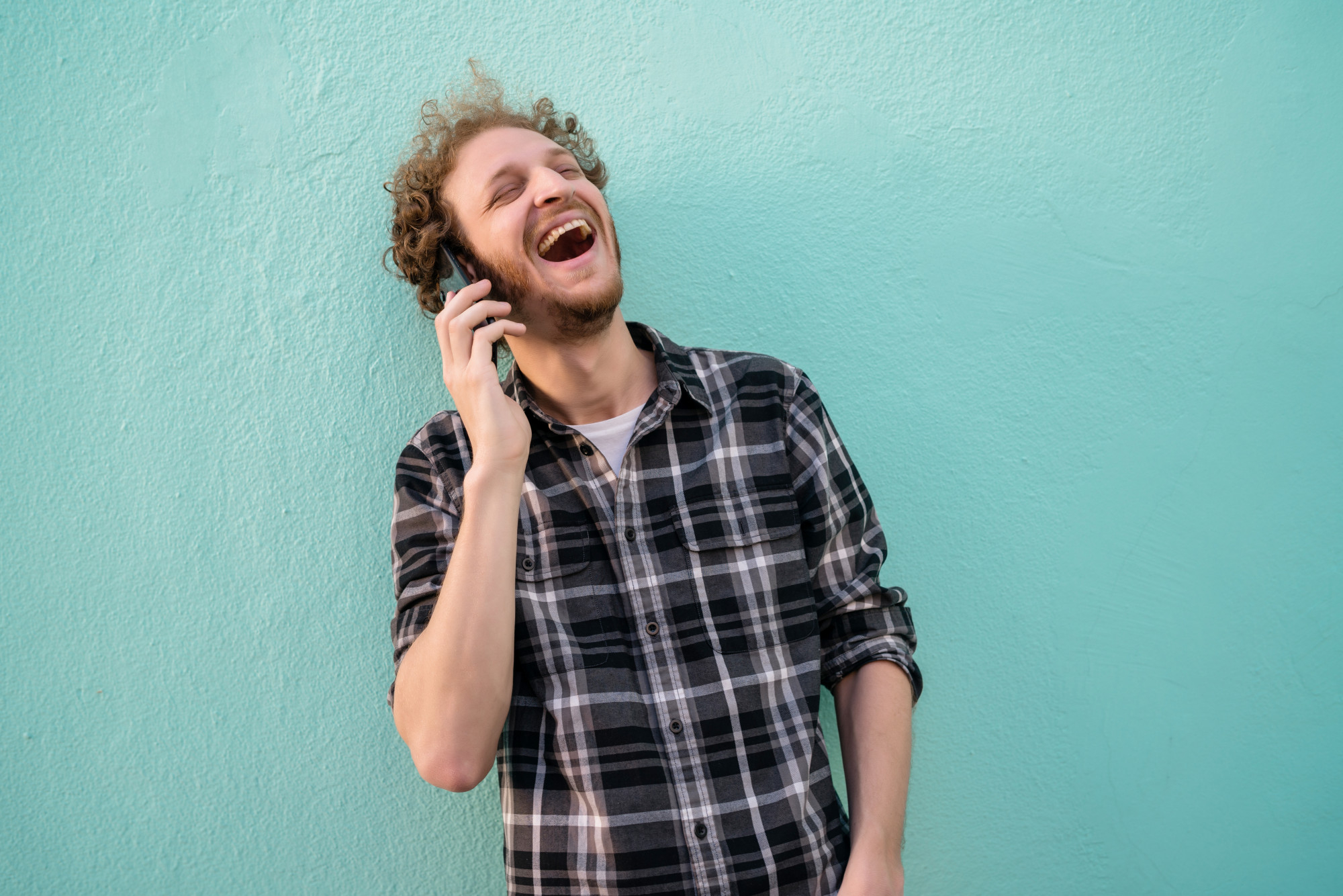 Un hombre se ríe mientras habla por teléfono | Fuente: Freepik