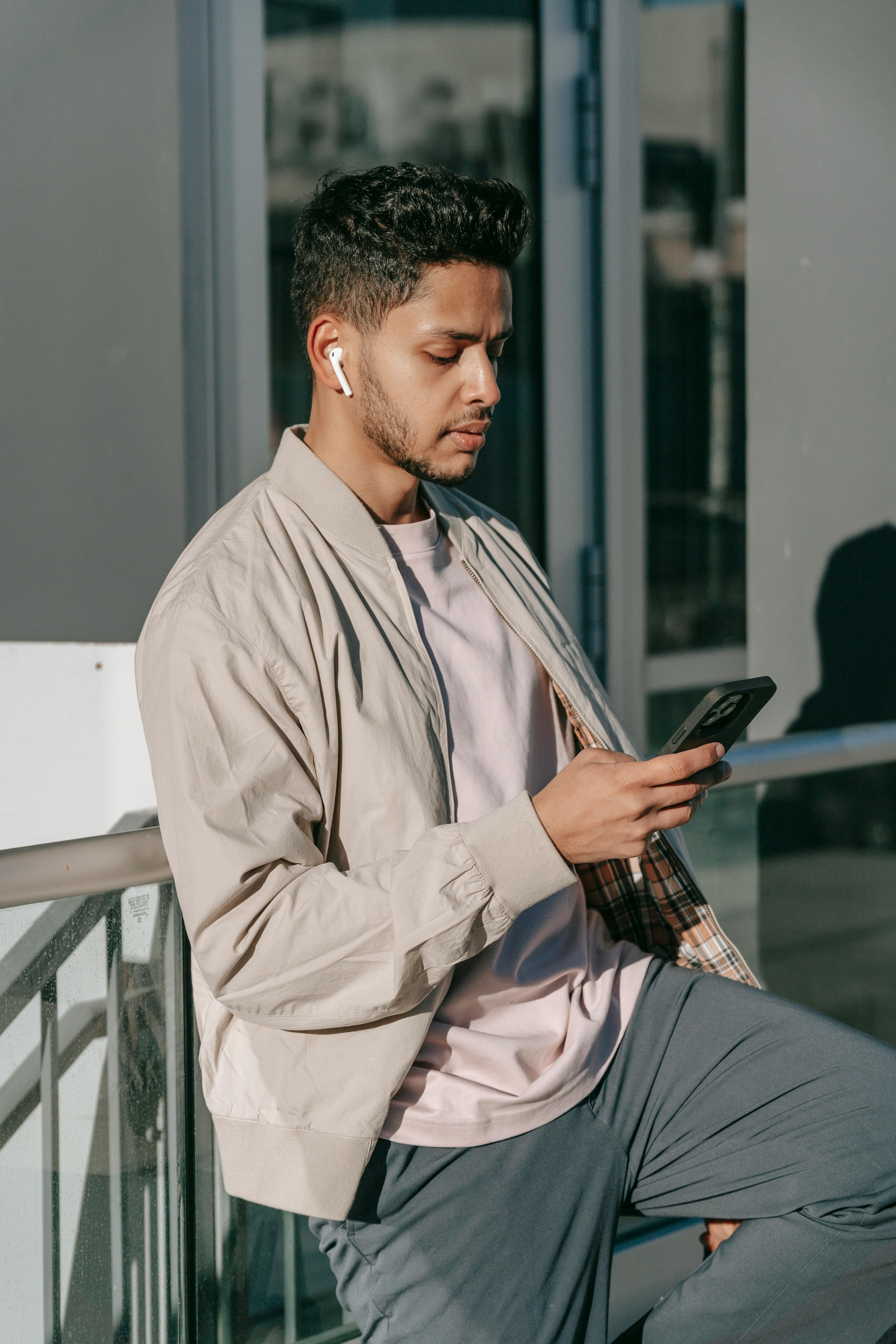 Hombre con auriculares usa su teléfono | Foto: Pexels
